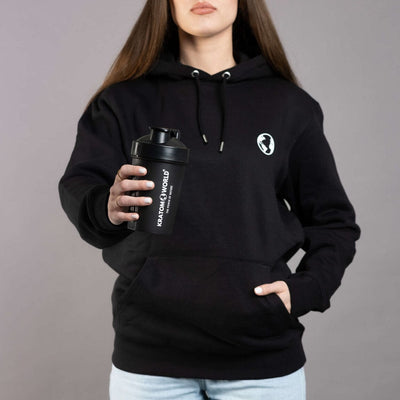 Shaker verde Kratom World pentru femei, prezentat alături de îmbrăcăminte sport