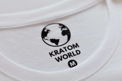 Detaliu al tricoului alb Kratom World cu etichetă de marcă